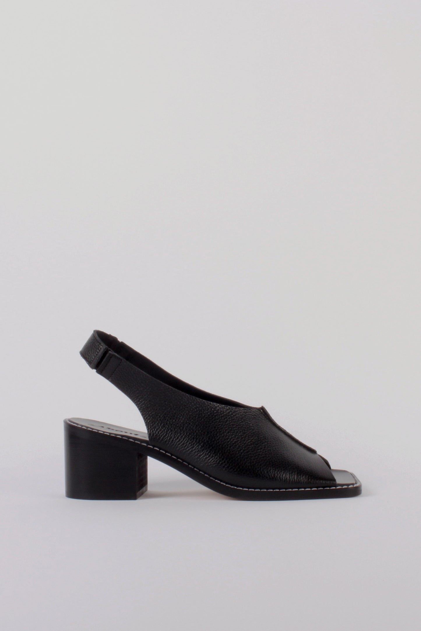 About Arianne block heel sling-back sandals made of black tumbled leather with raw edges