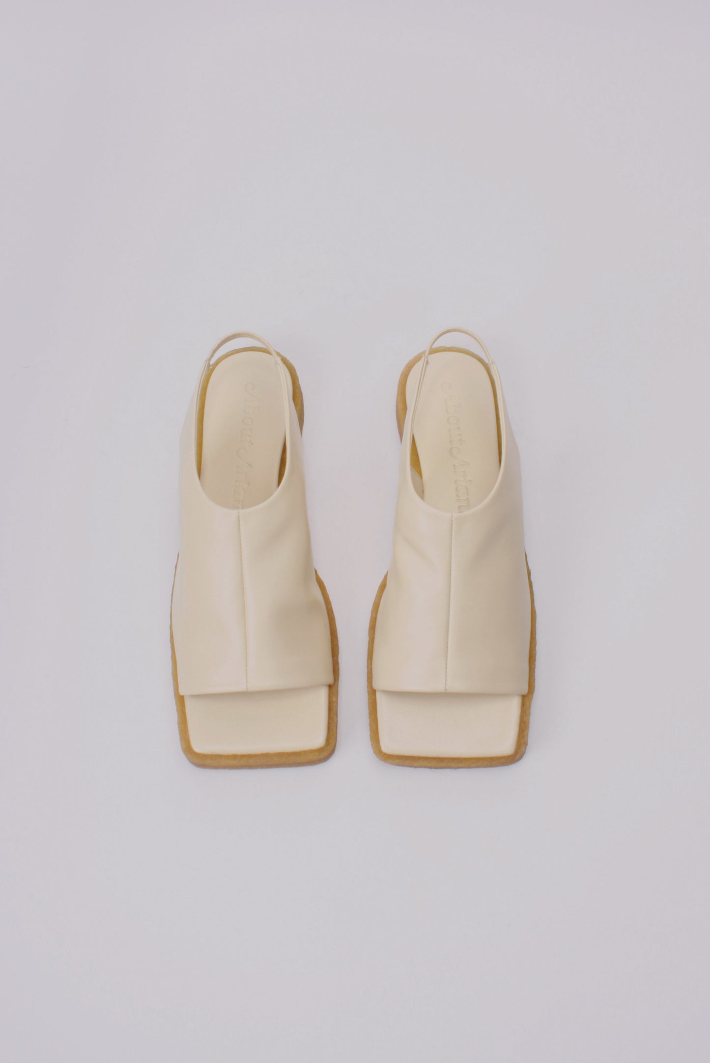 Unlined block platform sling-back sandals made of cream coloured lamb leather with a subtle shiny finish