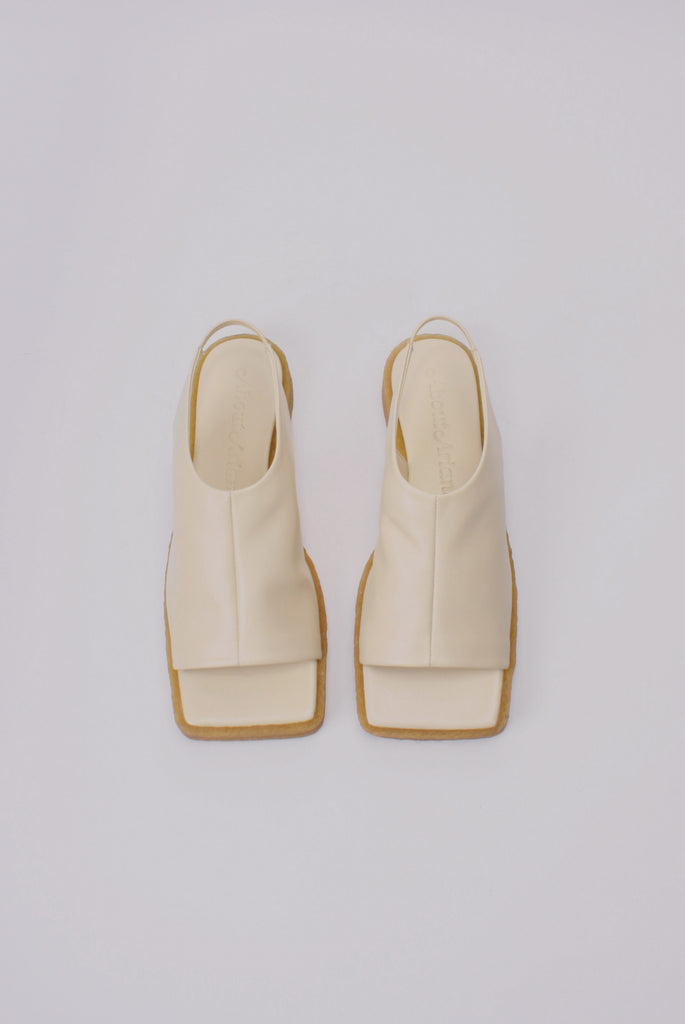 Unlined block platform sling-back sandals made of cream coloured lamb leather with a subtle shiny finish
