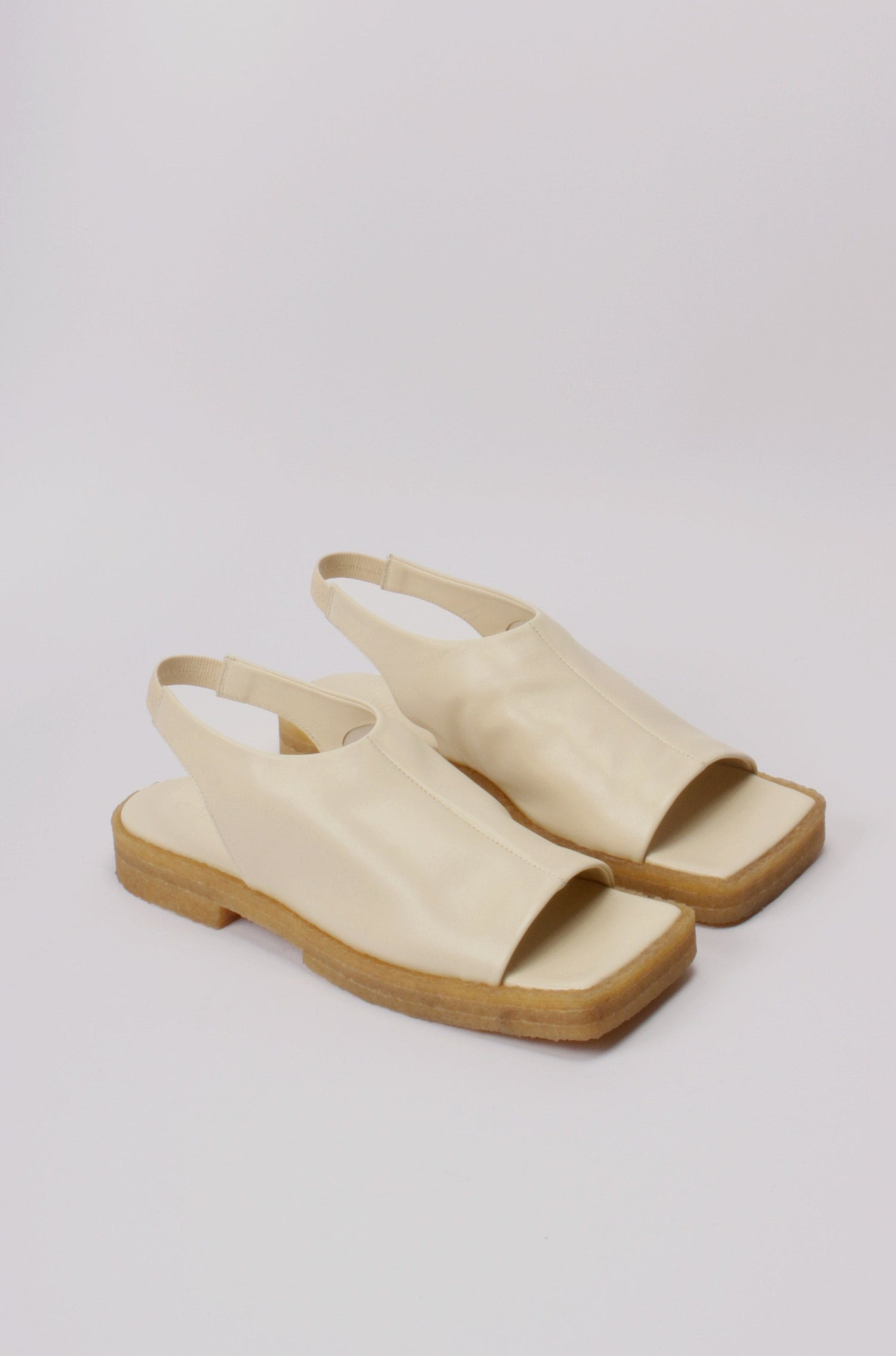 Unlined block platform sling-back sandals made of cream coloured lamb leather with a subtle shiny finish