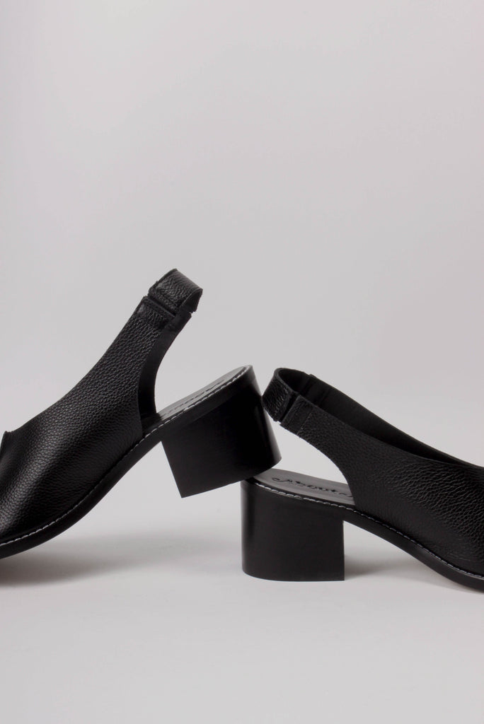 About Arianne block heel sling-back sandals made of black tumbled leather with raw edges