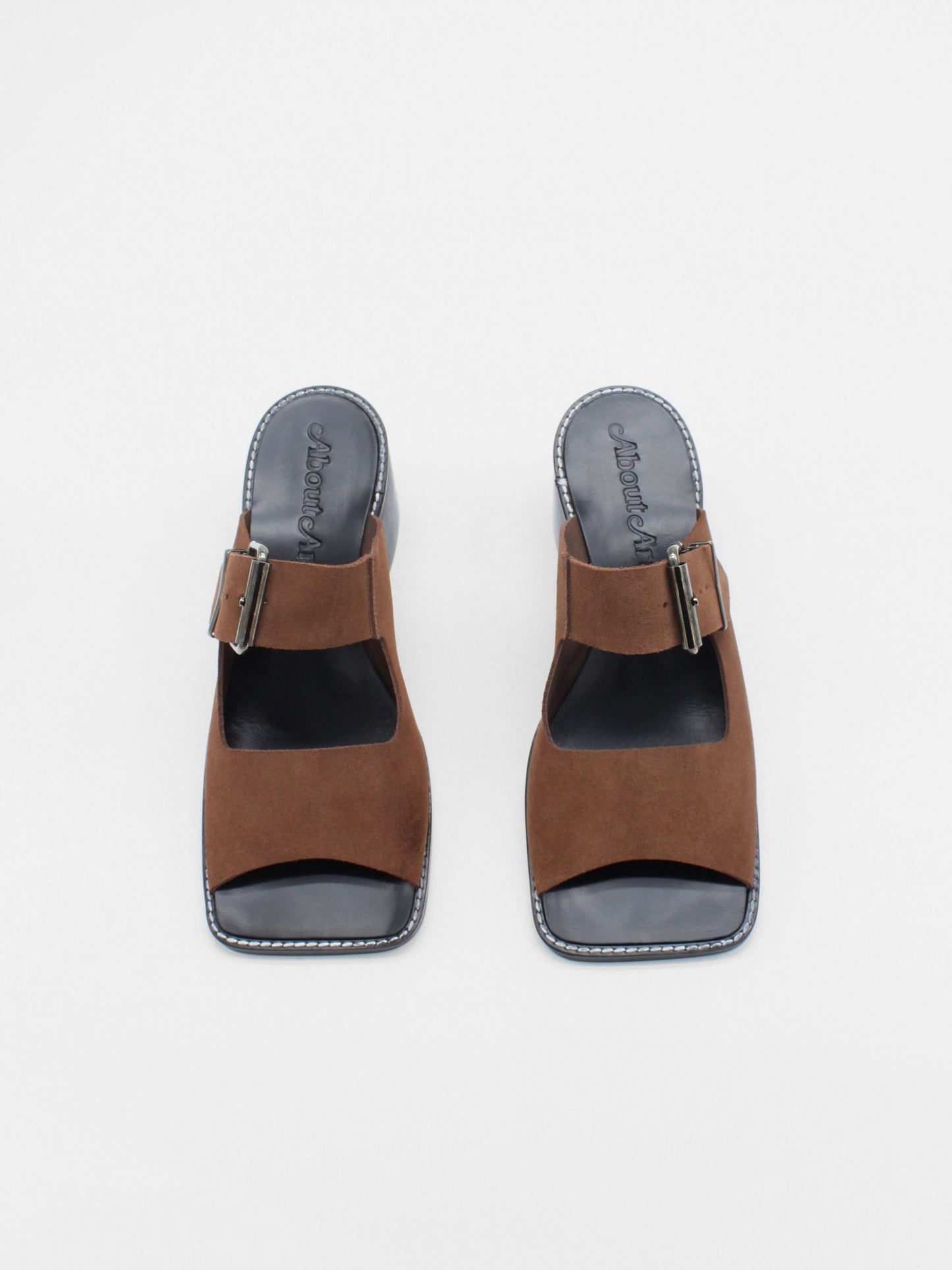 About Arianne mocha brown block heel mules made of brown split-cow leather with raw edges and a resined interior