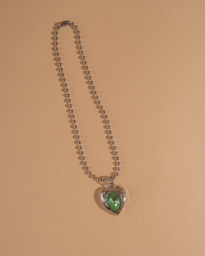 Silver-tone heart necklace set with clear glass stone on ball chain.