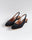 Slingback flats in a black vegan satin, made with a square toe, a unique hexagonal heel of 2.5 cm high, and an ornament piece on top that is lined with a charcoal fabric.