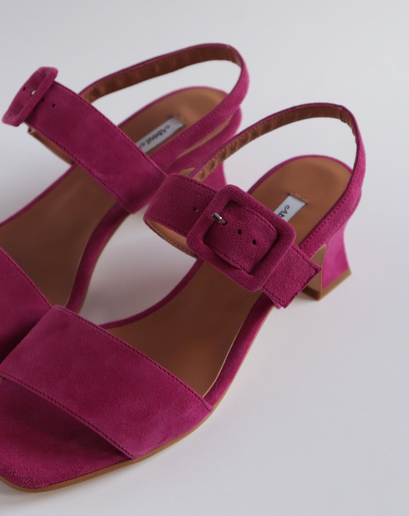 Fuchsia suede heeled sandals with buckle top strap  and fluted heel  available at Everything is Ease Toronto 