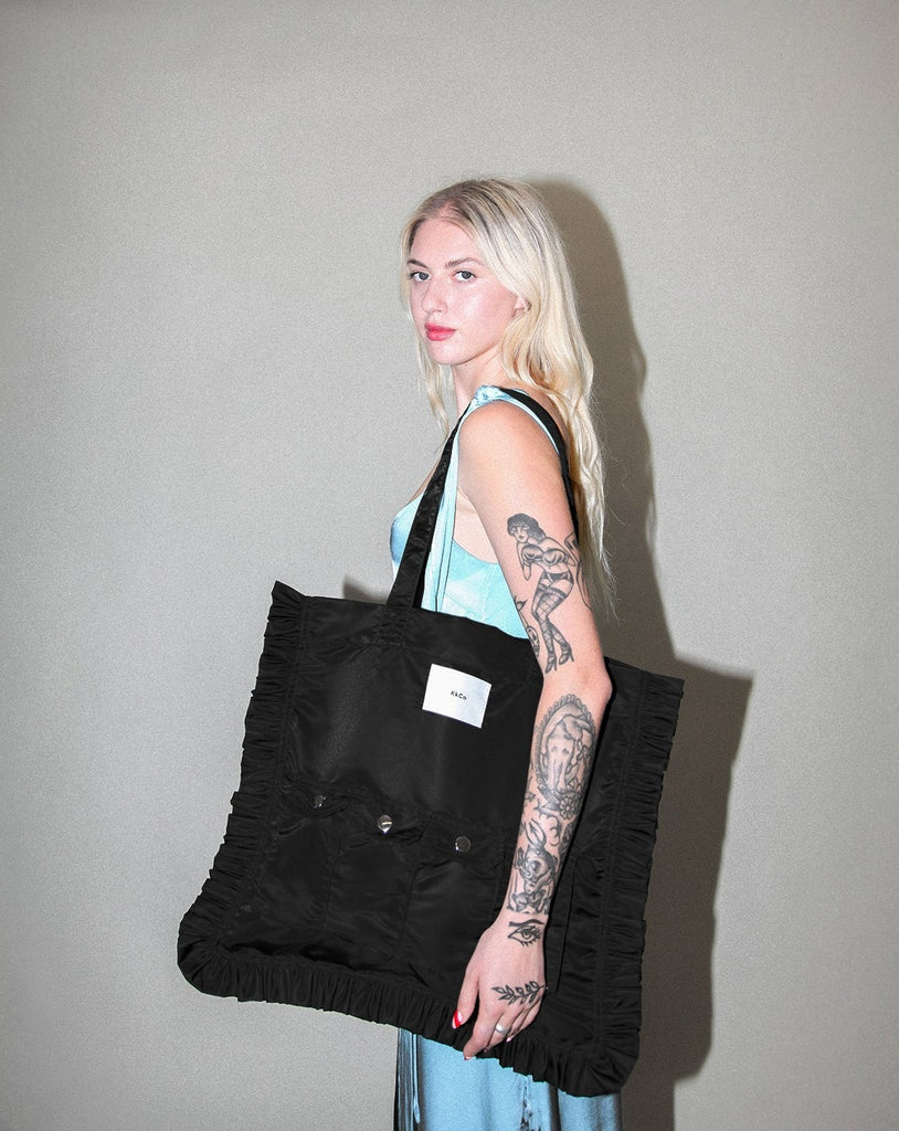 Black KkCo oversized Utility tote with ruffle and front pocket detail available at Ease Toronto