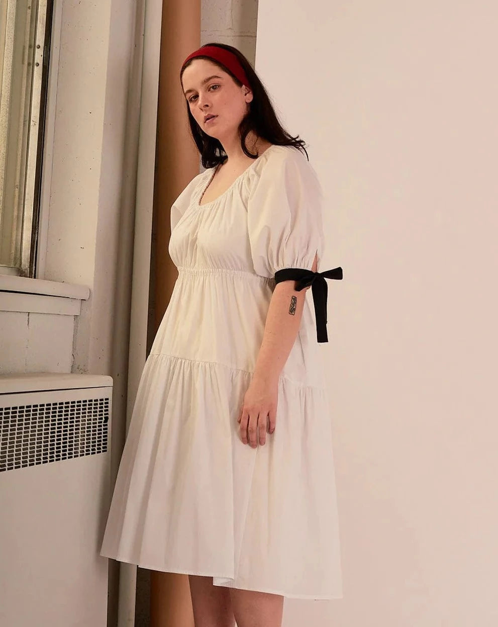 Overall white dress with extra puffy sleeves, gathered tiers, and black bow-tie details, the Jolen dress is both elegant and incredibly comfortable too. It's fully lined with cotton, slips on easily over head, and has pockets. 