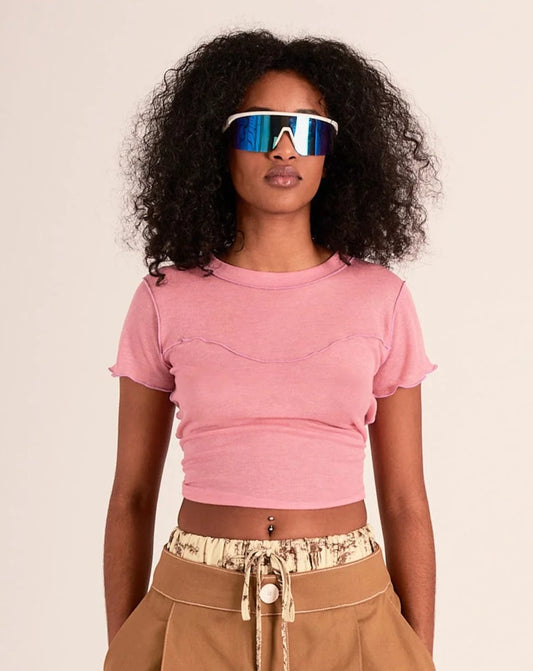 This cropped pink coloured tee is made out of a super soft blend of tencel and wool, but is still lightweight enough to wear during warm weather. The best parts are the exposed lilac coloured stitching and the super sweet ruffles on the hem and sleeves. It has a cropped fit that sits just above high-waisted jeans.