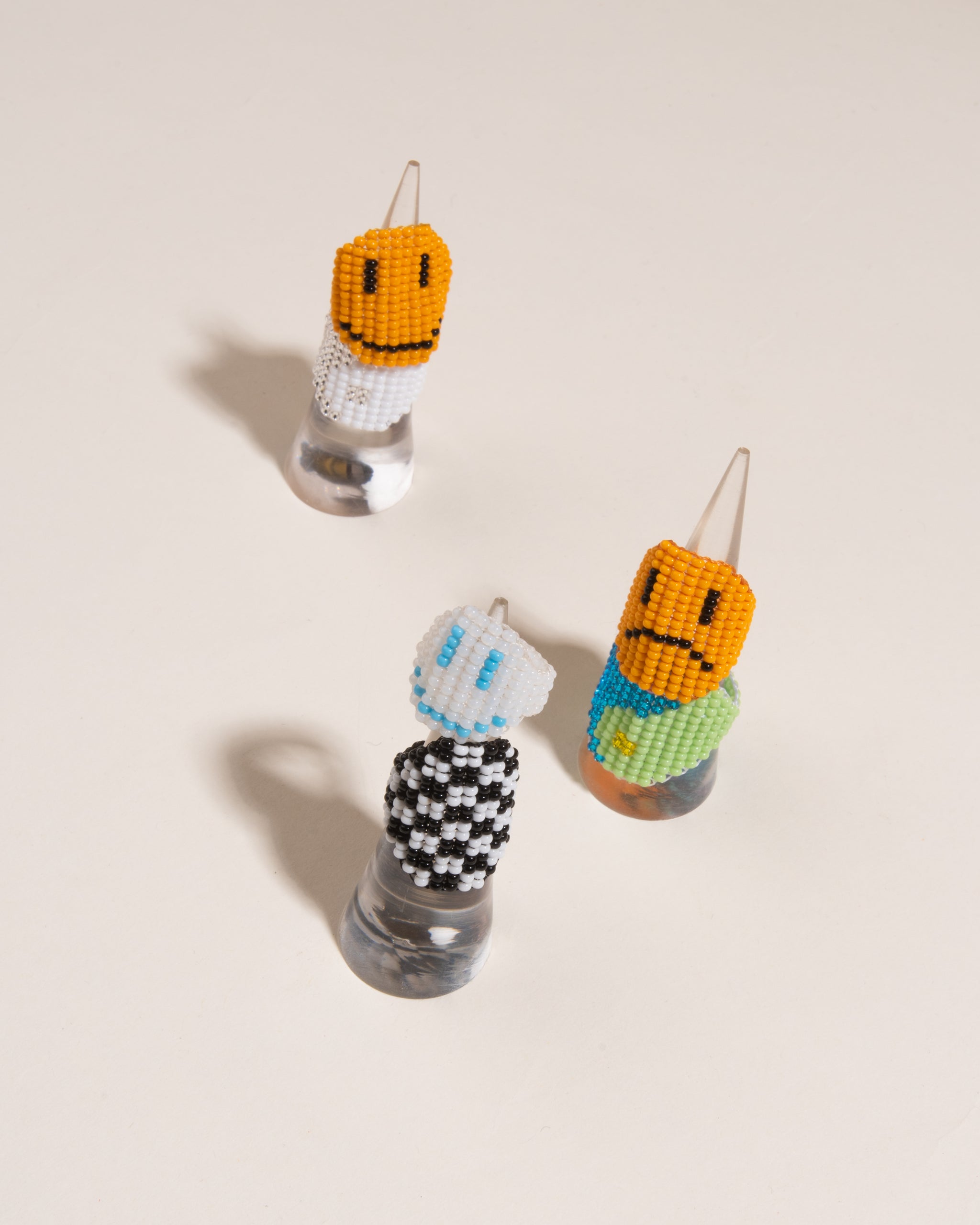 Beaded frowning face ring with orange background 